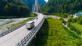 Truck crosses beautiful bridge in summer. Scene. Top view of truck carrying things driving across bridge on background