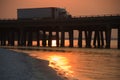 Truck crosses bridge in sunset