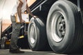 Truck Driver is Checking the Truck`s Safety of Wheels and Tires. Semi TraIler Truck Inspection Maintenance Repair Royalty Free Stock Photo