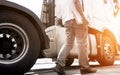 Truck driver holding clipboard walking with inspecting safety vehicle maintenance checklist semi truck. Royalty Free Stock Photo