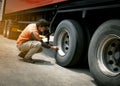 Truck driver inspecting safety daily check a truck wheels Royalty Free Stock Photo