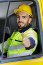 Truck driver man sitting in cabin giving thumbs-up Royalty Free Stock Photo