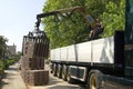 Truck driver, road builder unload lorry paving stones