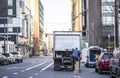 Truck driver of semi truck with box trailer unloading delivered cargo on the urban city street