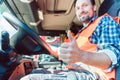 Truck driver sitting in cabin giving thumbs-up Royalty Free Stock Photo