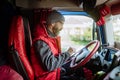 Truck driver sitting in truck, holding tablet, looking at cargo details, delivery schedule. Royalty Free Stock Photo