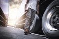 Truck Driver Walking and Checking A Truck Wheels and Tires. Inspection Maintenance and Safety forTruck Driving. Freight Truck.