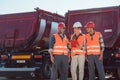 Truck drivers and dispatcher in front of lorries in freight forwarding company