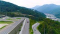 Truck drives along serpentine road. Scene. Top view of truck driving along serpentine uphill on background of green