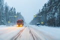 Truck drives with headlights on the winter road in a snow storm in the evening when snow is flying. Concept of driving Royalty Free Stock Photo