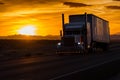 Truck driving along the highway next to a countryside field with the sun setting in the background Royalty Free Stock Photo