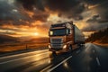 Truck driving on asphalt road in rural landscape at sunrise. Front view of delivery truck running on road with sunset. Fast