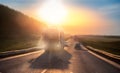 Truck driving on asphalt road in rural russia landscape with sun light, concept cargo transportation. Blur move effect