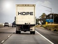 Truck driving down the freeway with HOPE written in large black letters on the back Royalty Free Stock Photo