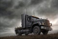 A truck is driving on the ground. Dark dramatic landscape with forest as background, gloomy sky, rainy clouds. Generative AI