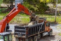 Truck with excavator loading for removal of debris construction waste building demolition