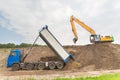 Truck and excavator together build a sound barrier