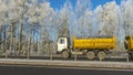 Truck goes on winter road. Van in the road of winter. Lorry car and cold landscape. Roadway and route snowy street trip