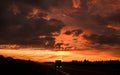 Truck hauling goods on empty highway at sunset