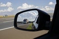 Truck on a highway seen in the rear view mirror on a summer day