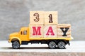 Truck hold block in word 31may on wood background Concept for date 31 month may