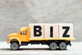 Truck hold block in word biz abbreviation of business on wood background
