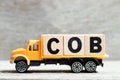 Truck hold block in word COB abbreviation of close of business on wood background