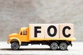 Truck hold block in word FOC Abbreviation of Free of charge on wood background