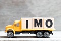 Truck hold block in word IMO Abbreviation of in my opinion on wood background