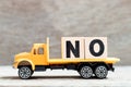 Truck hold block in word no on wood background