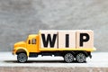 Truck hold block in word WIP Abbreviation of work in progress on wood background Royalty Free Stock Photo