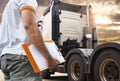 Truck inspection maintenance and repairing. A truck driver holding clipboard his checking safety to before driving semi truck Royalty Free Stock Photo