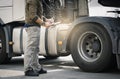 Truck inspection repairing and maintenance. A truck driver holding clipboard checking safety a truck wheels and tires. Royalty Free Stock Photo