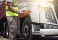 Truck inspection repairing and maintenance. A truck driver holding clipboard his inspecting daily maintenance checklist program. Royalty Free Stock Photo