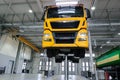 Truck on a lift in a car service. Servicing and repairing trucks in a large garage. Car service, repair, diagnostics, logistics Royalty Free Stock Photo