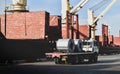 Truck load steel coils alongside big ship