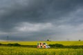 Truck loaded with colorful hives in the middle of a rapeseed field, in one cloudy day, in Romania