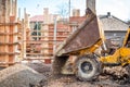 Truck loader excavating gravel and construction aggregates. Construction site with dumper truck and materials