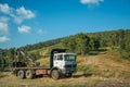 Truck log loader next to dirt road on terrain with trees Royalty Free Stock Photo