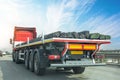 Truck with a long trailer loaded with metal rebar frame for the construction of a building drives along the highway