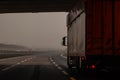 Truck or lorry just getting out of a tunnel on a foggy motorway. Dangerous ride with a truck