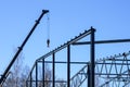 Truck mounted crane with a telescoping boom at constructing a metal carcas of a new building