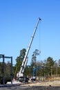 Truck mounted crane with a telescoping boom at constructing a metal carcas of a new building