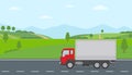 Truck moving on asphalt road along the green fields in rural landscape. Transport services concept.