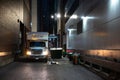 Truck parked in an illuminated, narrow alleyway in the evening