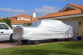 Truck with a protective cover in driveway of a modest house with an orange tile roof Royalty Free Stock Photo