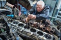 Truck repair service. Serviceman measuring cylinder Royalty Free Stock Photo