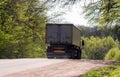 Truck rides on a slope on a forest road. Back view. Royalty Free Stock Photo