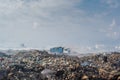 Truck riding at the garbage dump full of smoke, litter, plastic bottles,rubbish and trash at tropical island Royalty Free Stock Photo