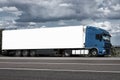 Truck on road with white blank container, blue sky, cargo transportation concept Royalty Free Stock Photo